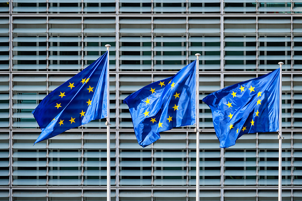 Banderas de la Unión Europea ondeando frente a un edificio institucional